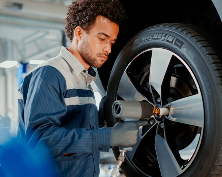 Volvo Protection Plan technician removing a wheel from a volvo